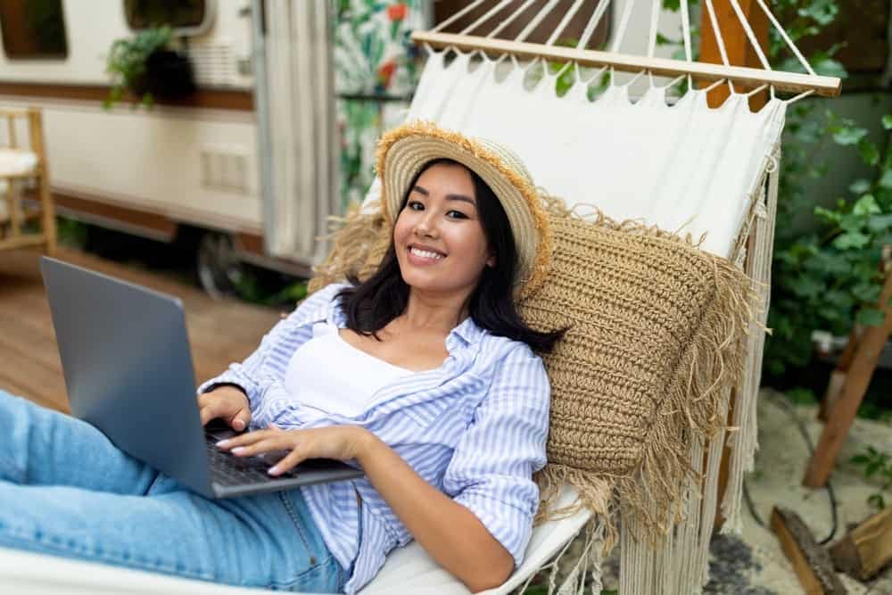 A woman working in a hammock with her laptop.