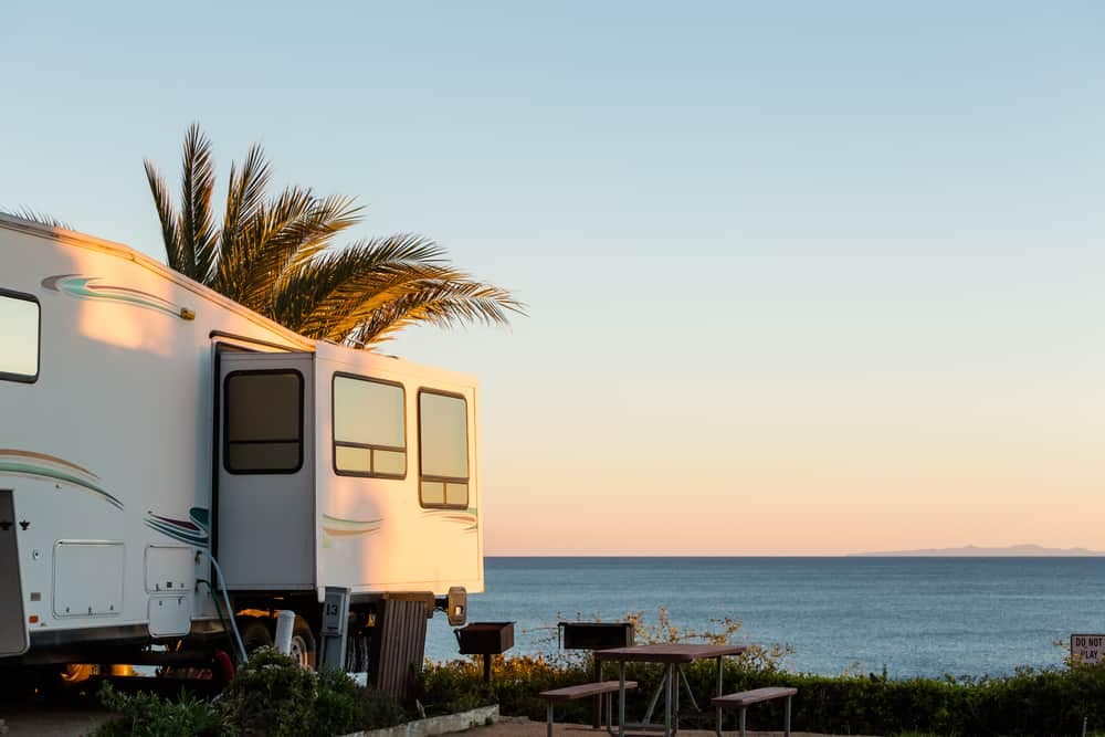 Description: A couple's RV parked in front of the ocean at a Florida campground.