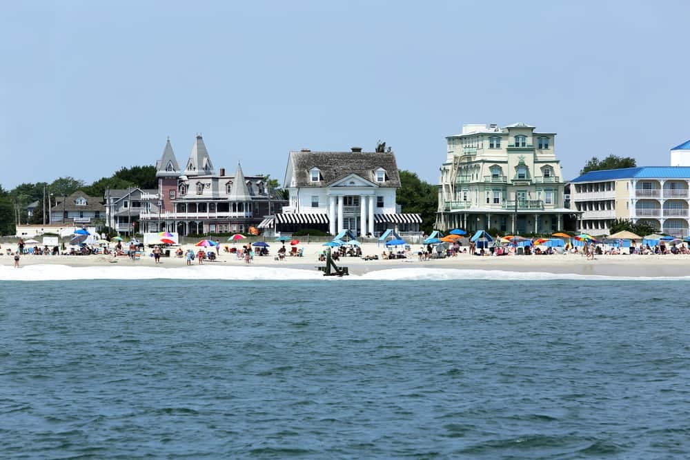 A group of people on a beach with houses in the background at Cape May Camping Resort.