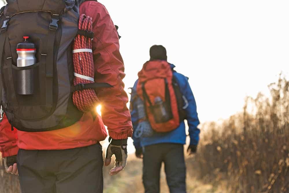 Two campers walking down a trail with backpacks.