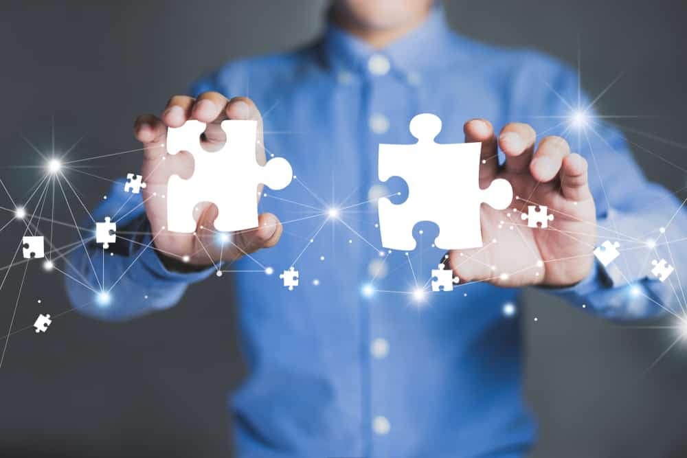 A man holding two pieces of a puzzle as Hipcamp expands into France through acquisition.
