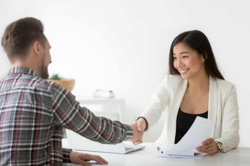 The Senior Vice President of Lippert, an Aftermarket Engineering company, shaking hands with a man at a desk.