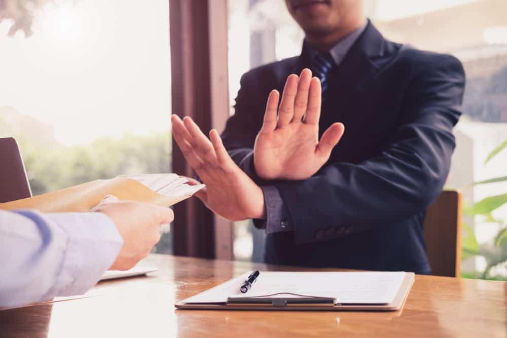 A man in a suit is giving a handshake to another man in a suit during the Oceano Advisory Council meeting.