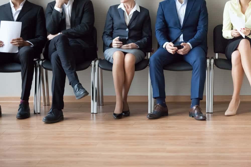 A group of employers sitting in a row, discussing job openings for the month of March.