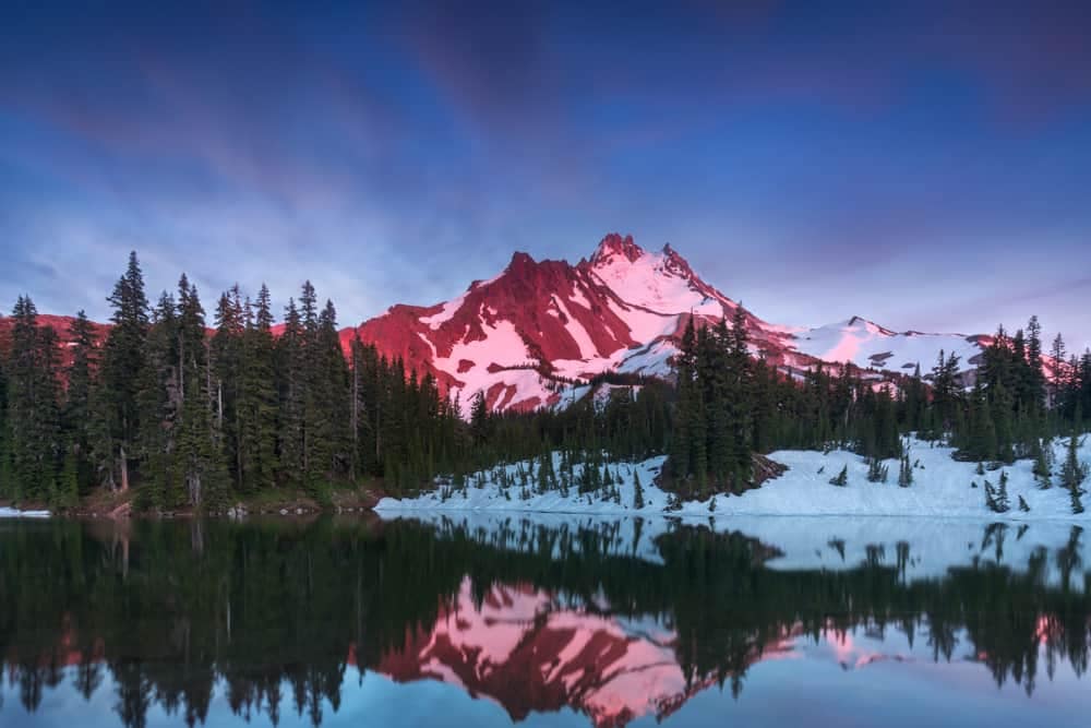 A mountain is reflected in a lake at sunset in Deschutes National Forest.