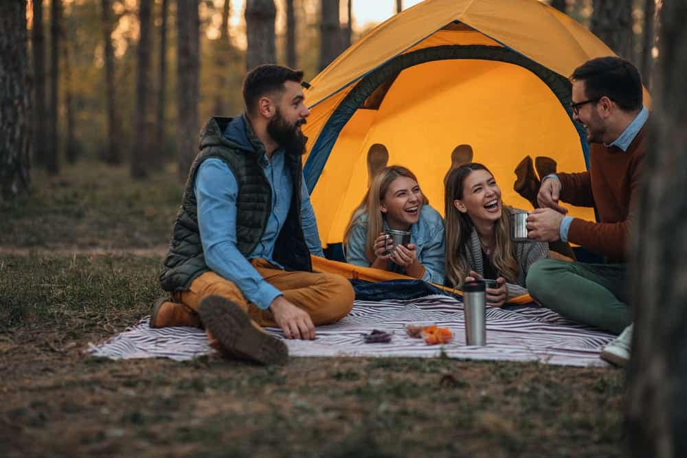 A group of friends sitting around a tent in the East Bluff Campground in Keweenaw County.