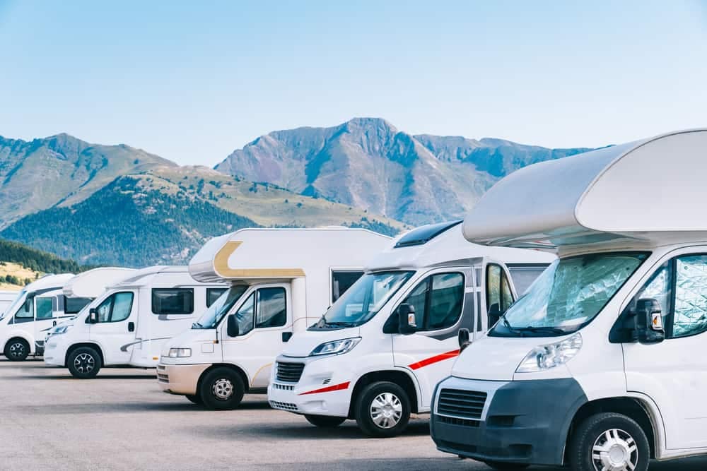 A row of RVs parked in front of majestic mountains, showcasing the potential growth and rental opportunities through RVRA.