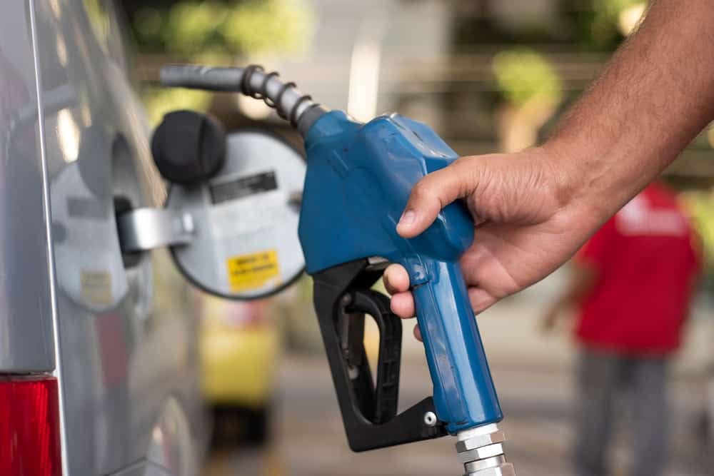 A man is filling up a car with gas amidst Diesel Fuel Supply Issues.