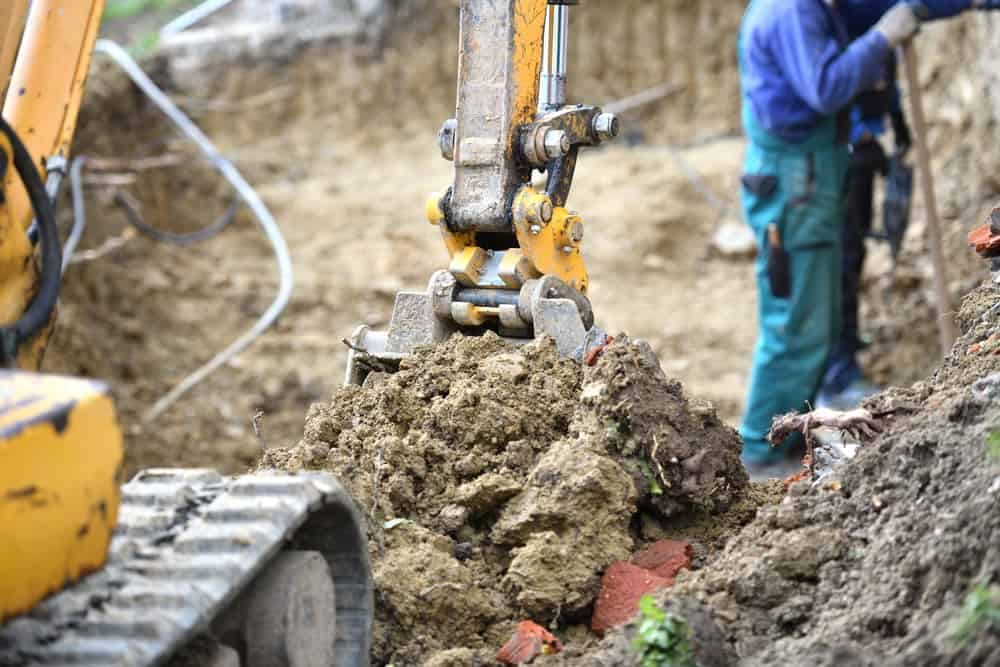 An excavator is digging a hole in Veterans Memorial Park in Canon Falls.