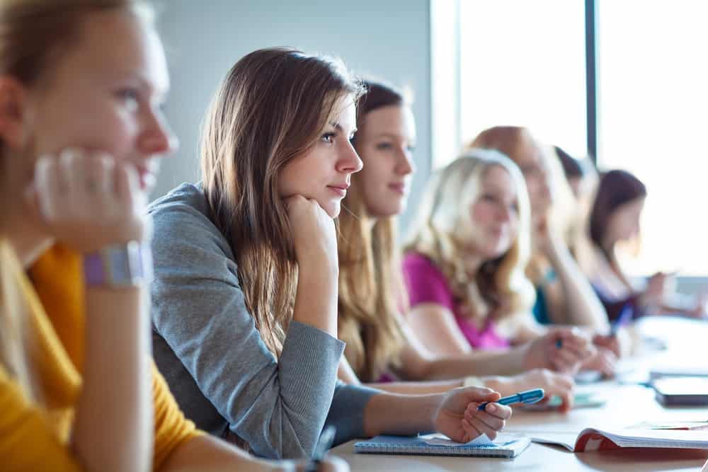 An All-Female Tech Training Class, consisting of a group of women, sitting at a table in a classroom.
