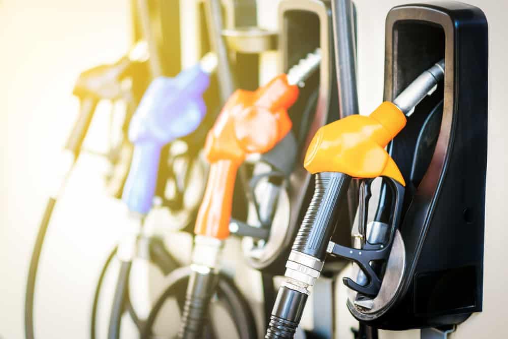 A group of gas pumps with different colored nozzles, providing refueling options for Memorial Day travelers.