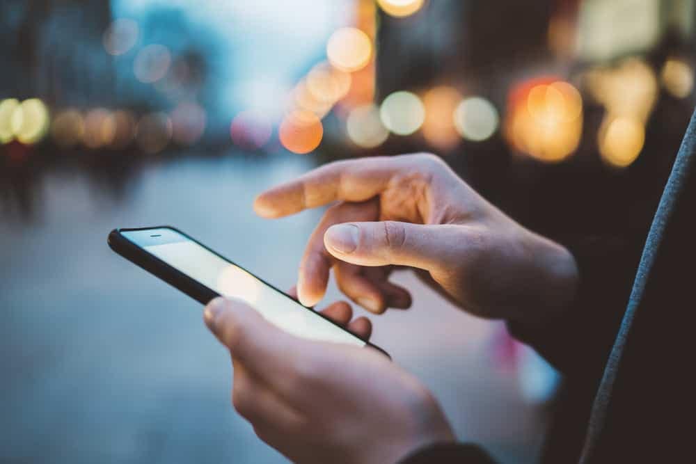 A person using the Lippert RV App on a smartphone in a city at night, exploring the newly redesigned features.