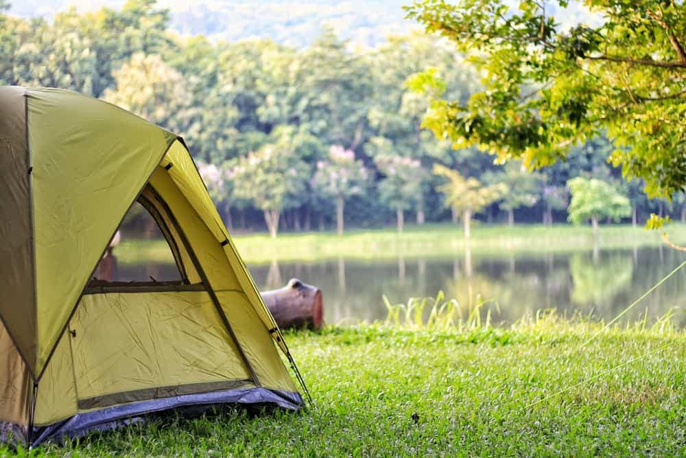 A campsite is set up on the grass near a lake during the May Long Weekend at an Alberta Parks location.