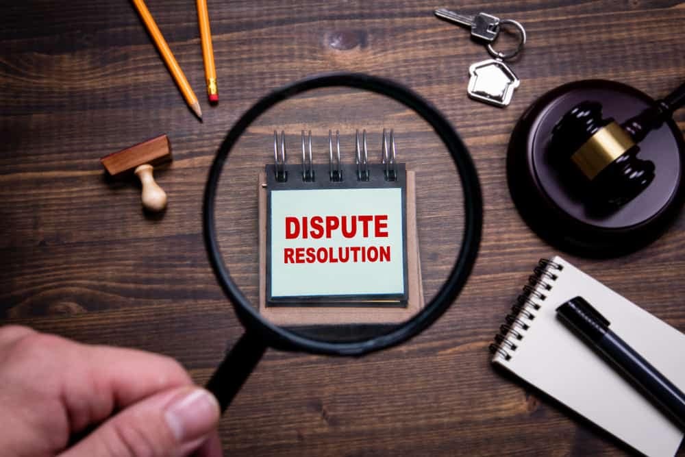 A magnifying glass with the words "dispute resolution" is displayed prominently.