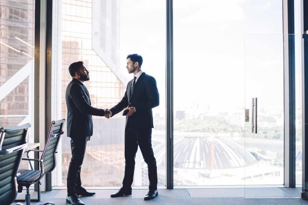 Two businessmen shaking hands in an Anthem RV office.