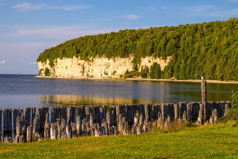 A wooden fence in front of a body of water at a Michigan State Park.
