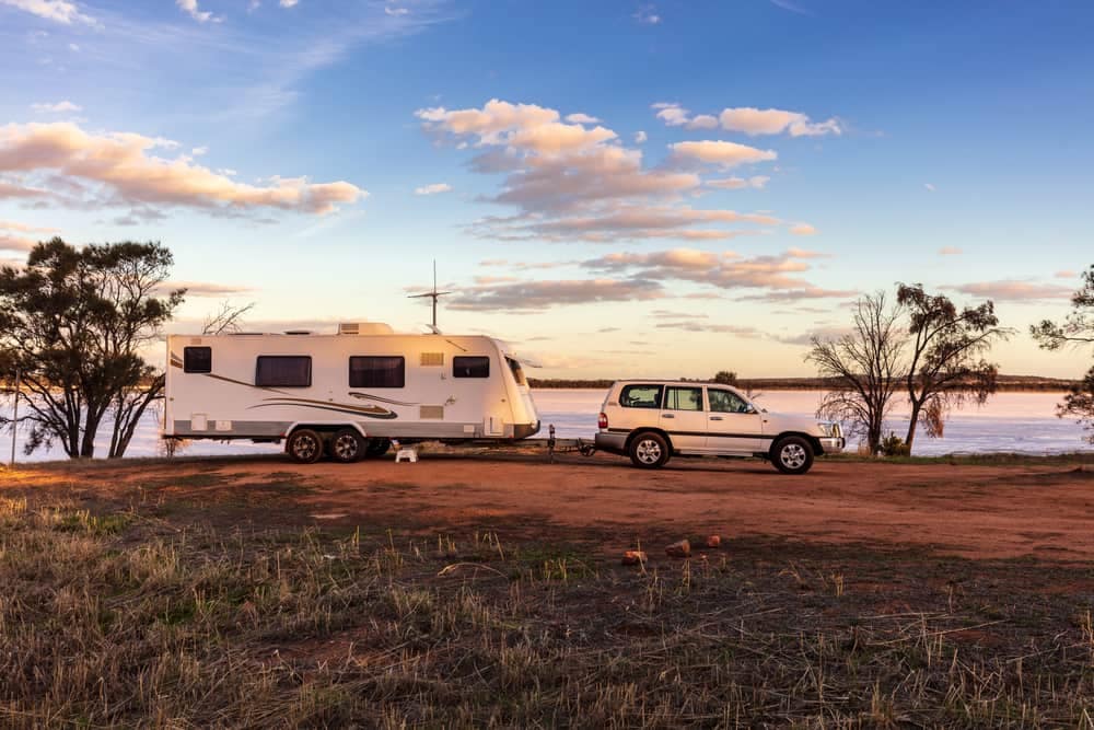 An rv parked on a dirt road near a lake in Michigan.