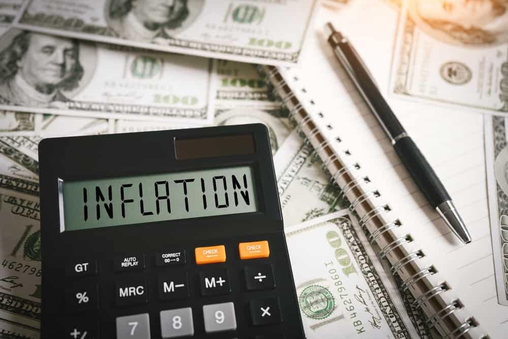 A calculator with the word inflation sitting on top of a pile of money, reflecting four-decade high U.S. inflation rates.
