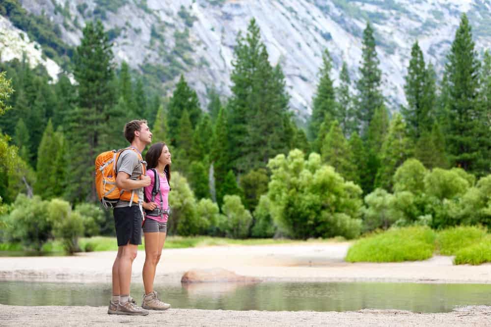 Two Americans standing by a river in Yosemite National Park.