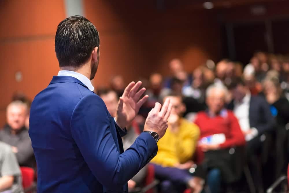 A best-selling author speaking at the RV Aftermarket Conference in front of an eager audience.