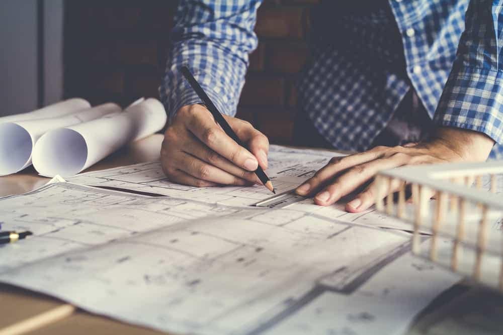 A man is working on blueprints at a desk at Airdriehill Quarry.