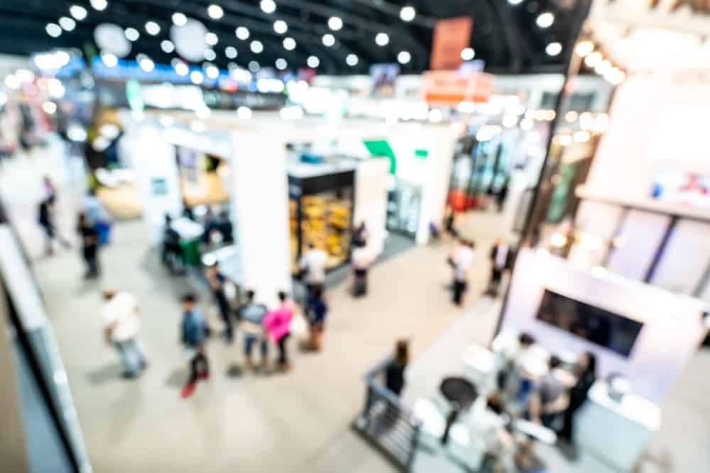 A blurry image of people walking around an RV Expo exhibition hall.