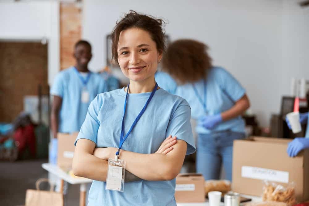 A group of women volunteers in blue uniforms standing in a room.