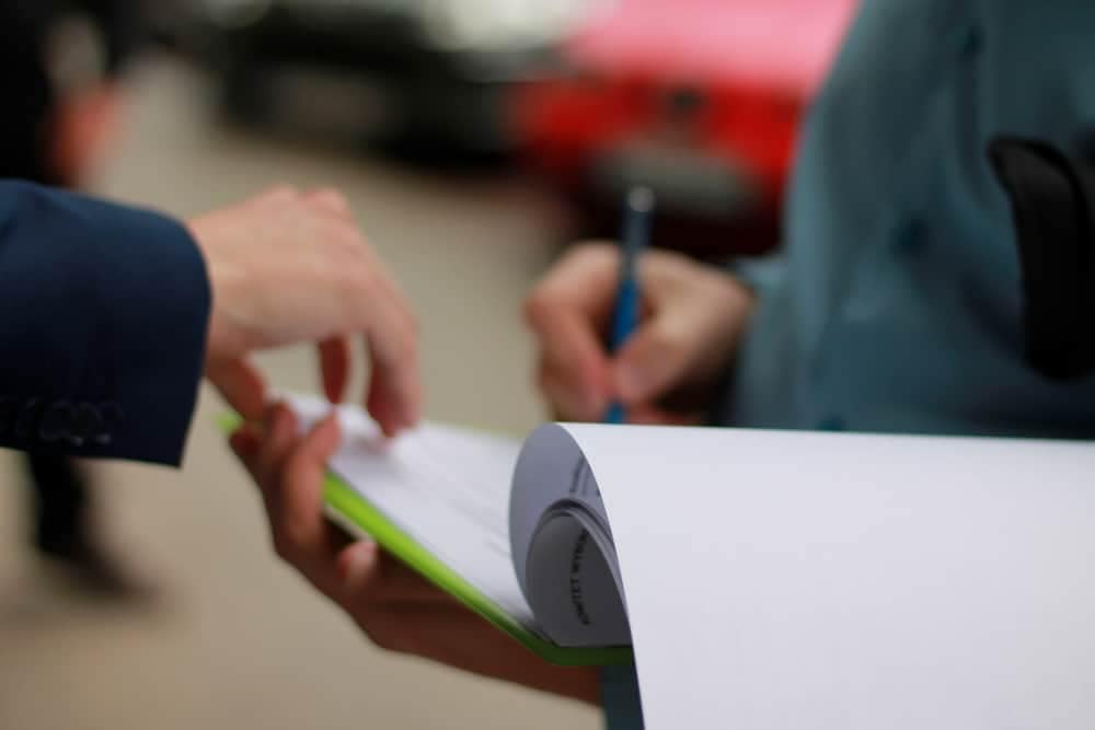 A businessman handing over a petition to another person.