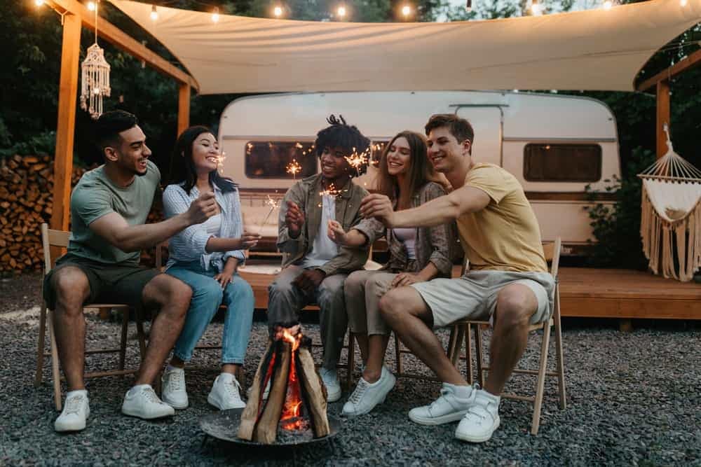 A group of British Columbians sitting around a campfire, following the Camper's Code in BC Parks.