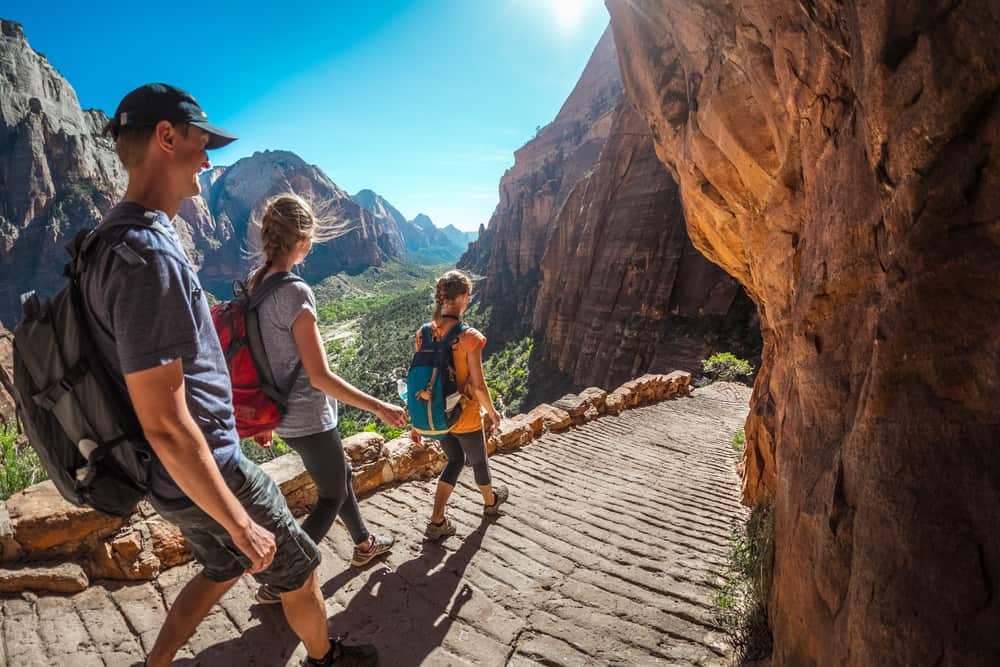 A group of people hiking through a canyon in Zion National Park on a Fee-Free Day.