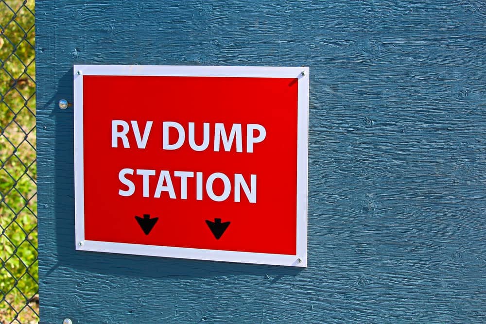 A red and white RV dump station sign on a fence at the Vernon Council Sani-Dump Site.