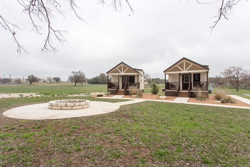Two tiny homes in a Hill County Campground with a fire pit.