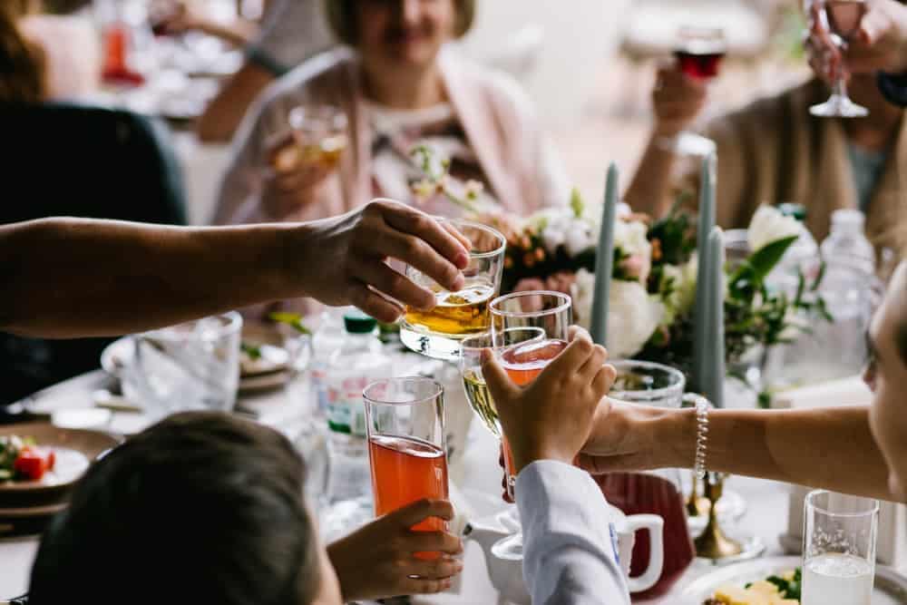 A diverse group of people toasting at an outdoor dinner party, celebrating an anniversary.