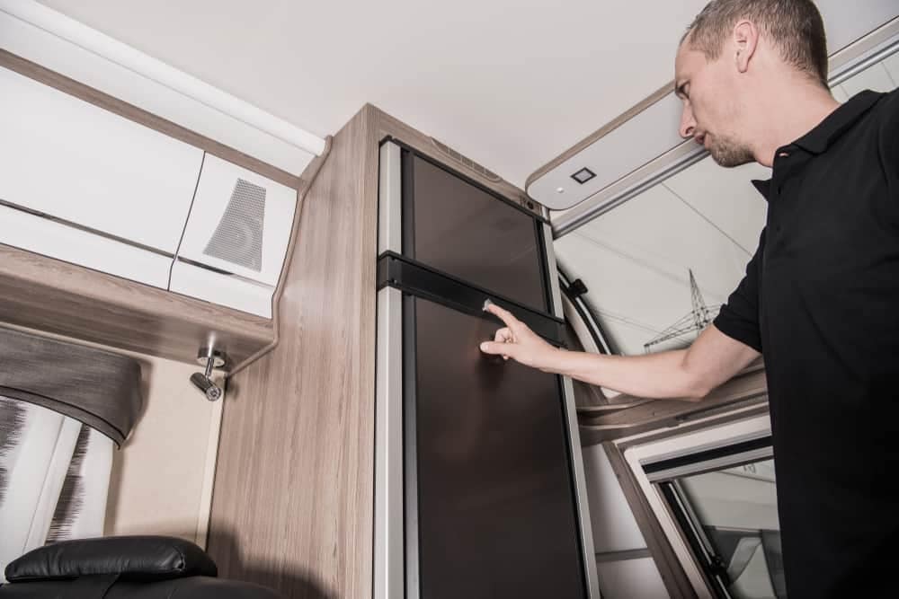 A man pointing to a door in an RV.