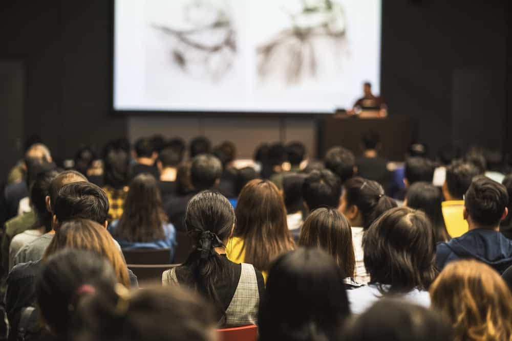 A group of people attending a regulatory & safety compliance seminar in a lecture hall.