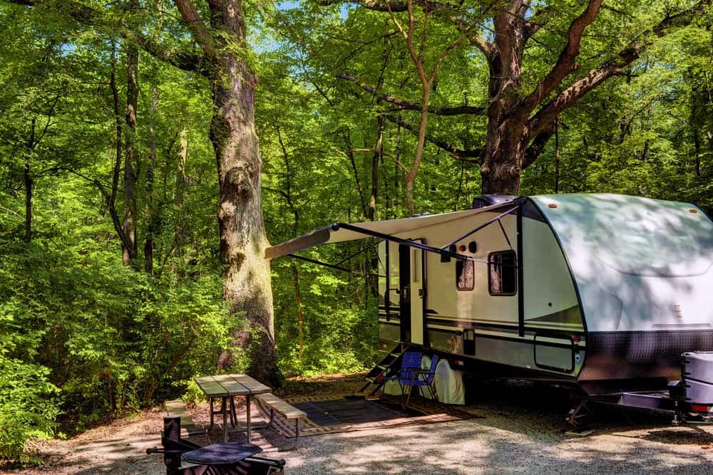 A caravan parked in a wooded area.