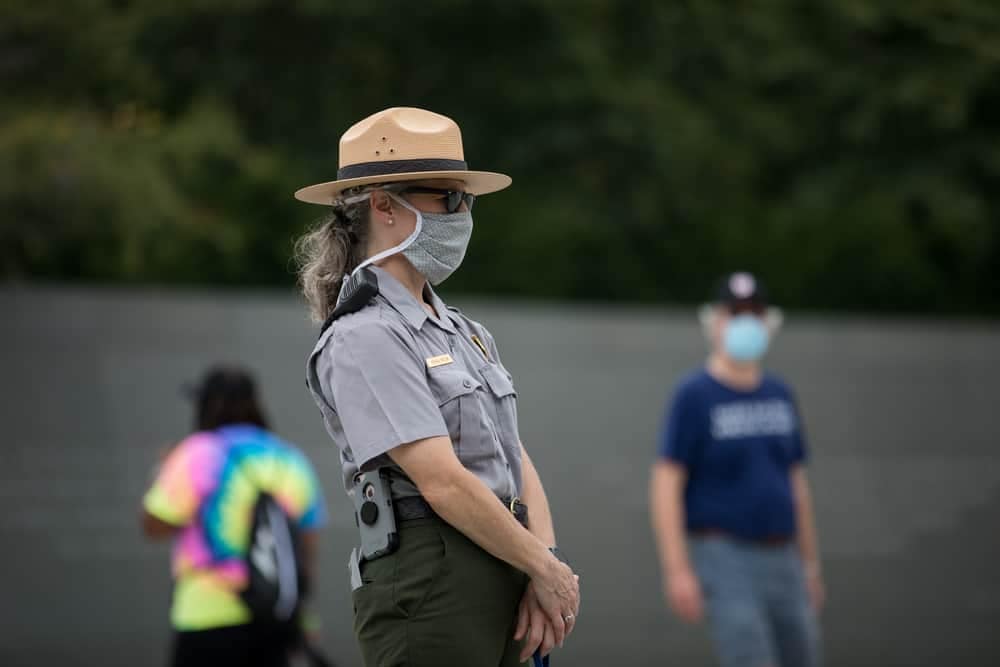 A woman wearing a face mask stands next to a group of people in Shenandoah National Park.