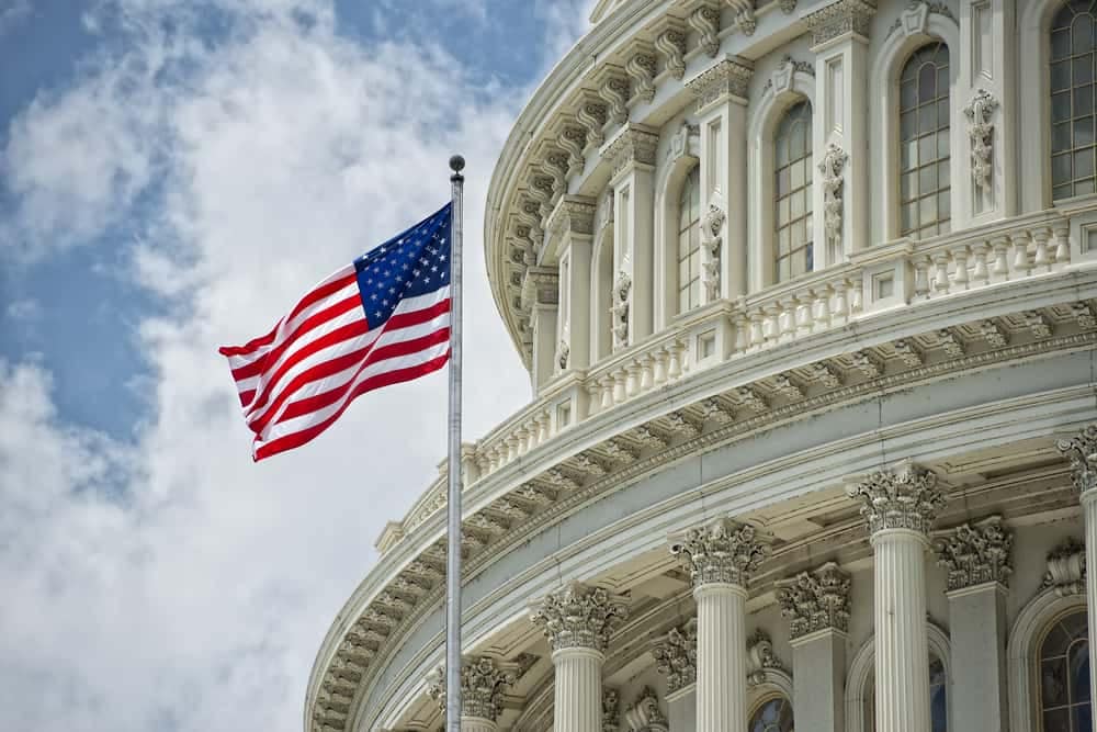 An American flag flies over the Capitol building in Washington, D.C., representing the United States.