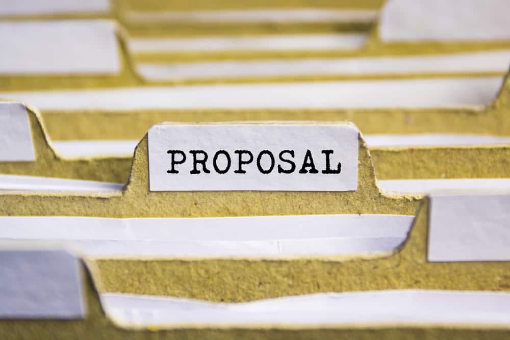 A file folder labeled "proposal" for a local economy project related to a farm owner's glamping site.