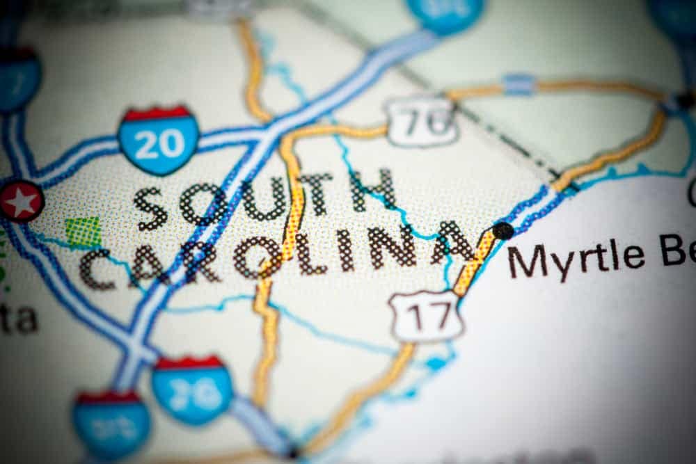 A map of South Carolina is shown on a computer screen, highlighting various state tourism spots.