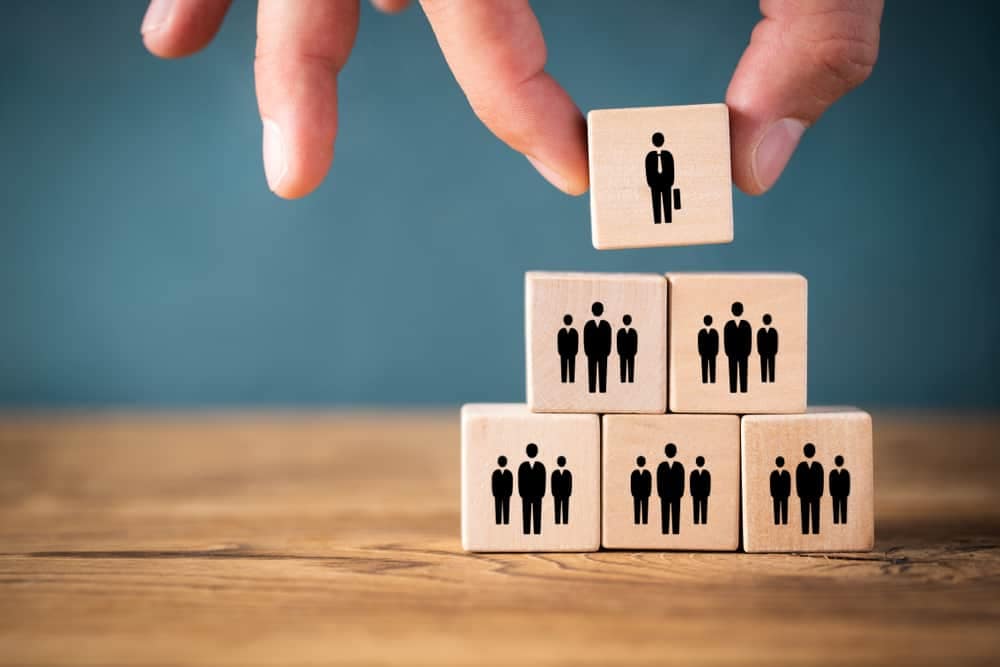 A hand is skillfully placing wooden blocks with miniature people on top of them, creating a captivating transition effect reminiscent of a RVIA board.