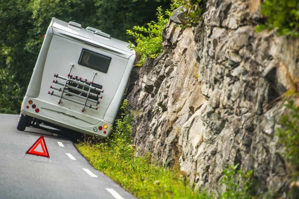 An RV parked on the side of a mountain road offering picturesque views and tranquility.