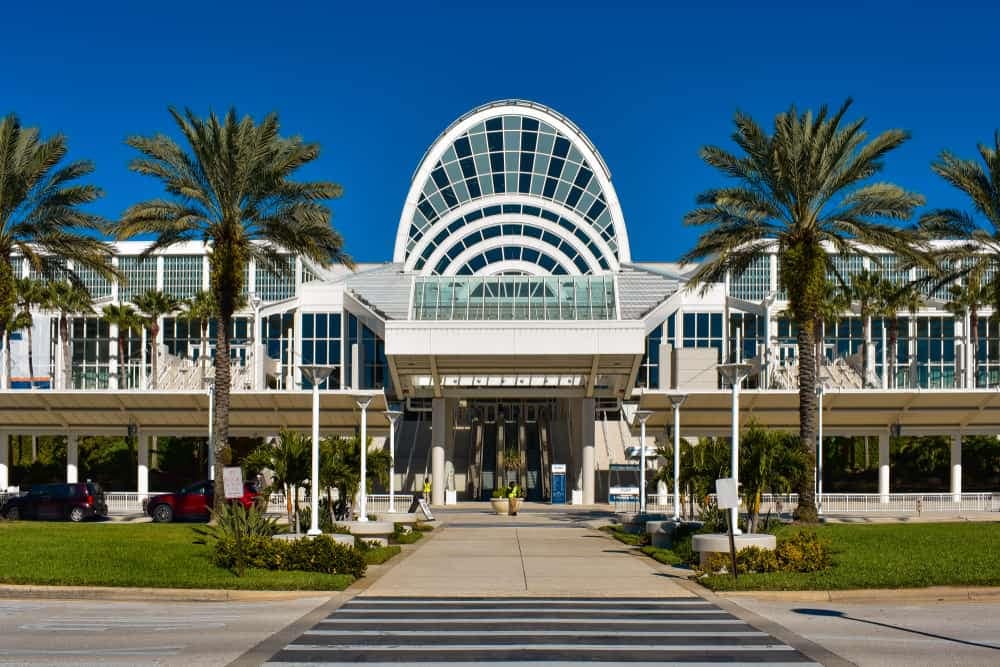A bigger building with palm trees in front of it.
