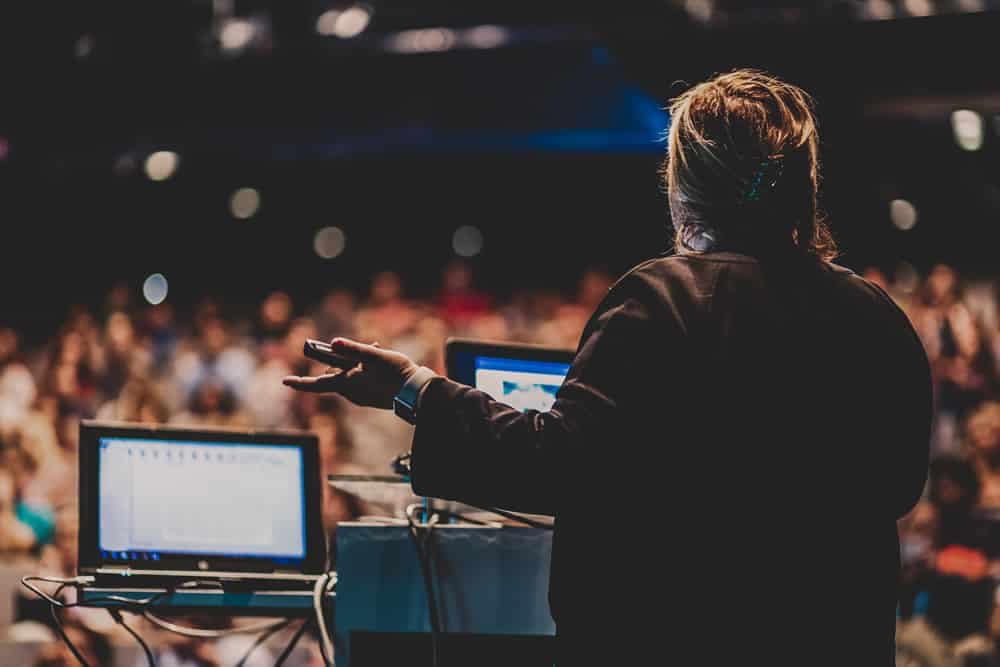 An Economist giving a presentation in front of an audience at an Open House event.
