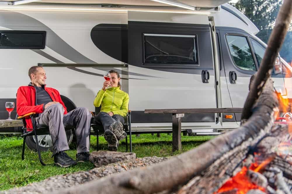 Two people sitting by a campfire in front of an RV at a Wisconsin campground on Labor Day.