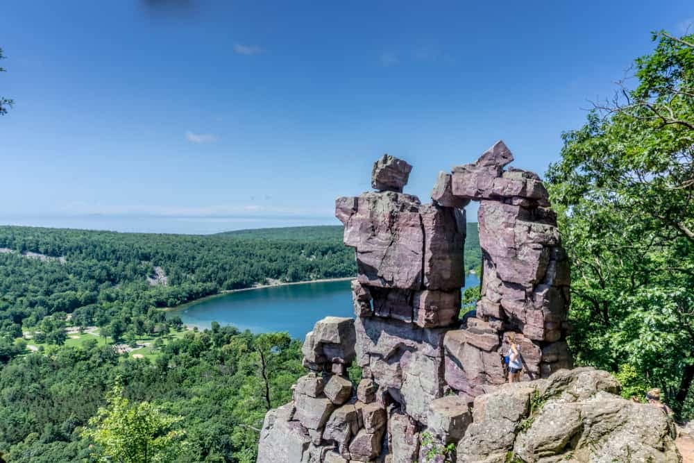 A group of people standing on top of a rock overlooking a lake during Free State Parks Day Passes in Wisconsin Libraries.