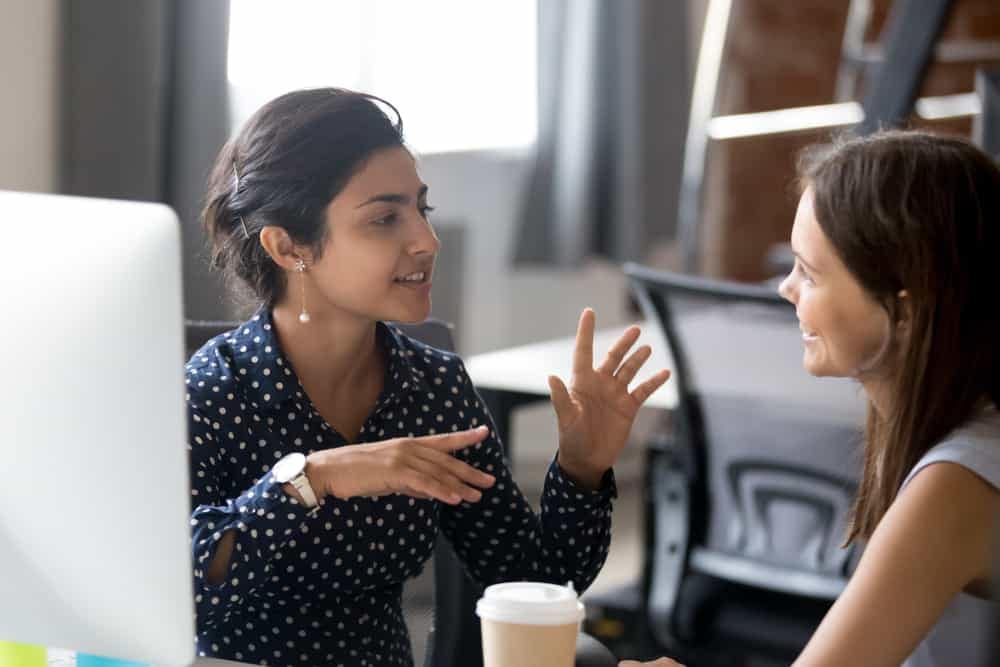 Two women discussing the RVWA mentorship program in an office setting.