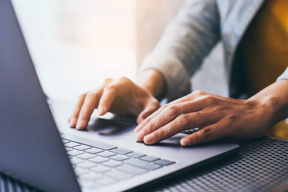 A woman typing on a laptop computer while researching online retail and the RV industry.