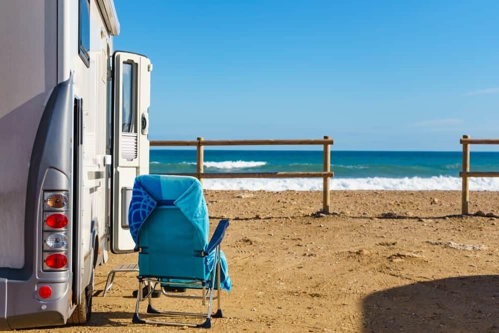 Dry Flush Australia introduces an rv parked on the beach near the ocean.