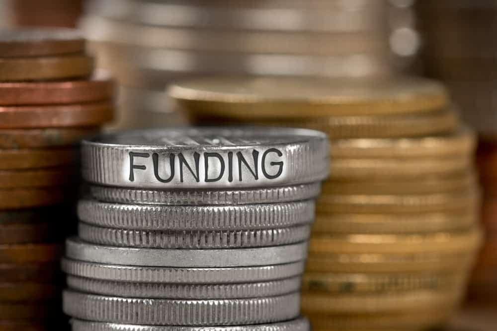 A stack of coins with the word funding on them, representing the generous support provided by the Grant Program.